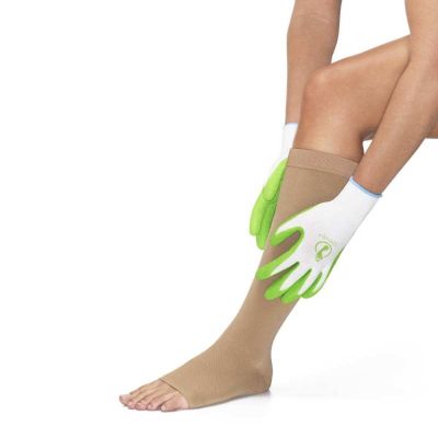 Frau zieht ihren Kompressionsstrumpf mit Hilfe von Steve Gloves Grip Handschuhen an 